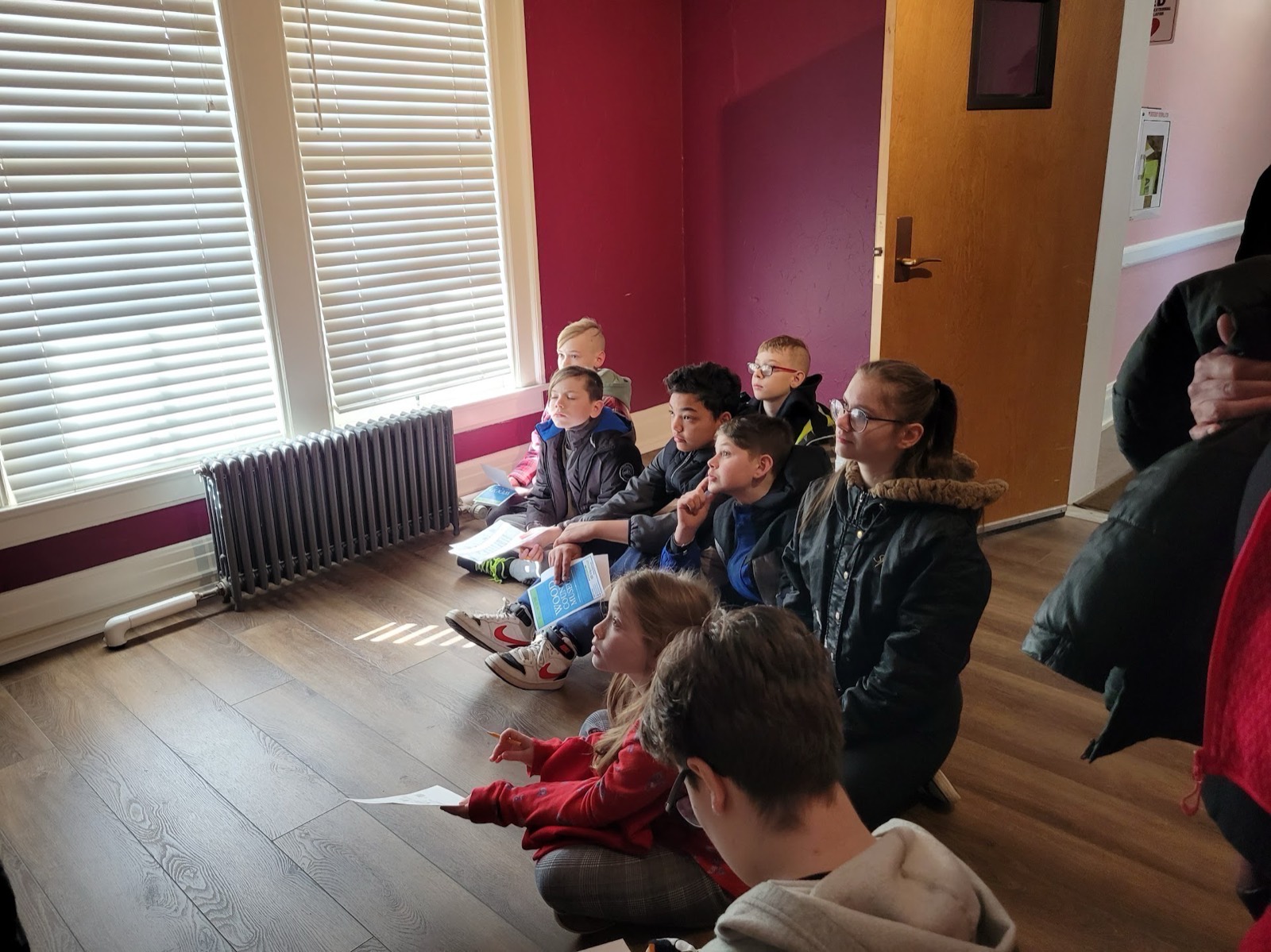 CCA students sitting together listening closely to a museum guide