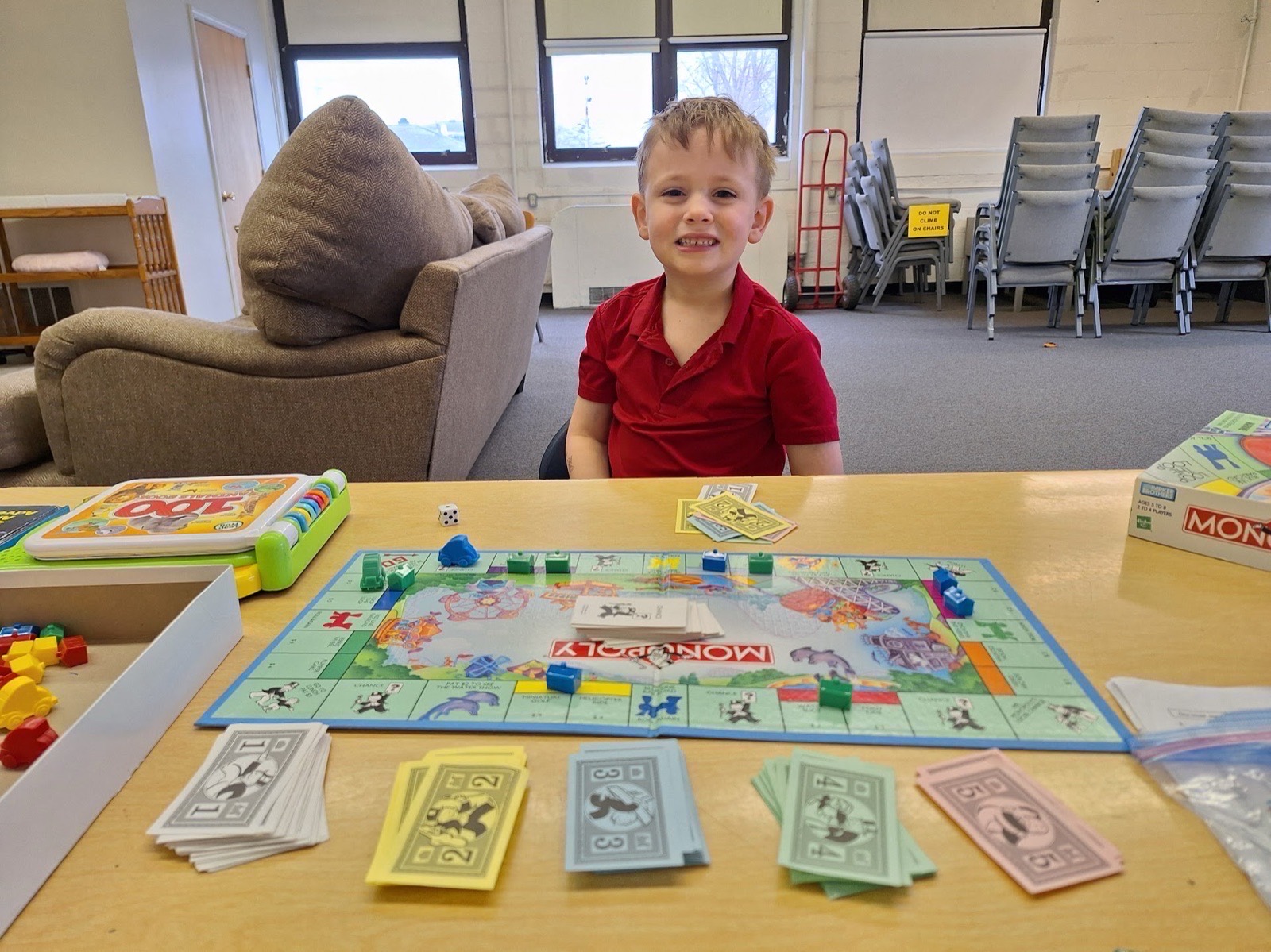 A CCA student smiling over a board game at school